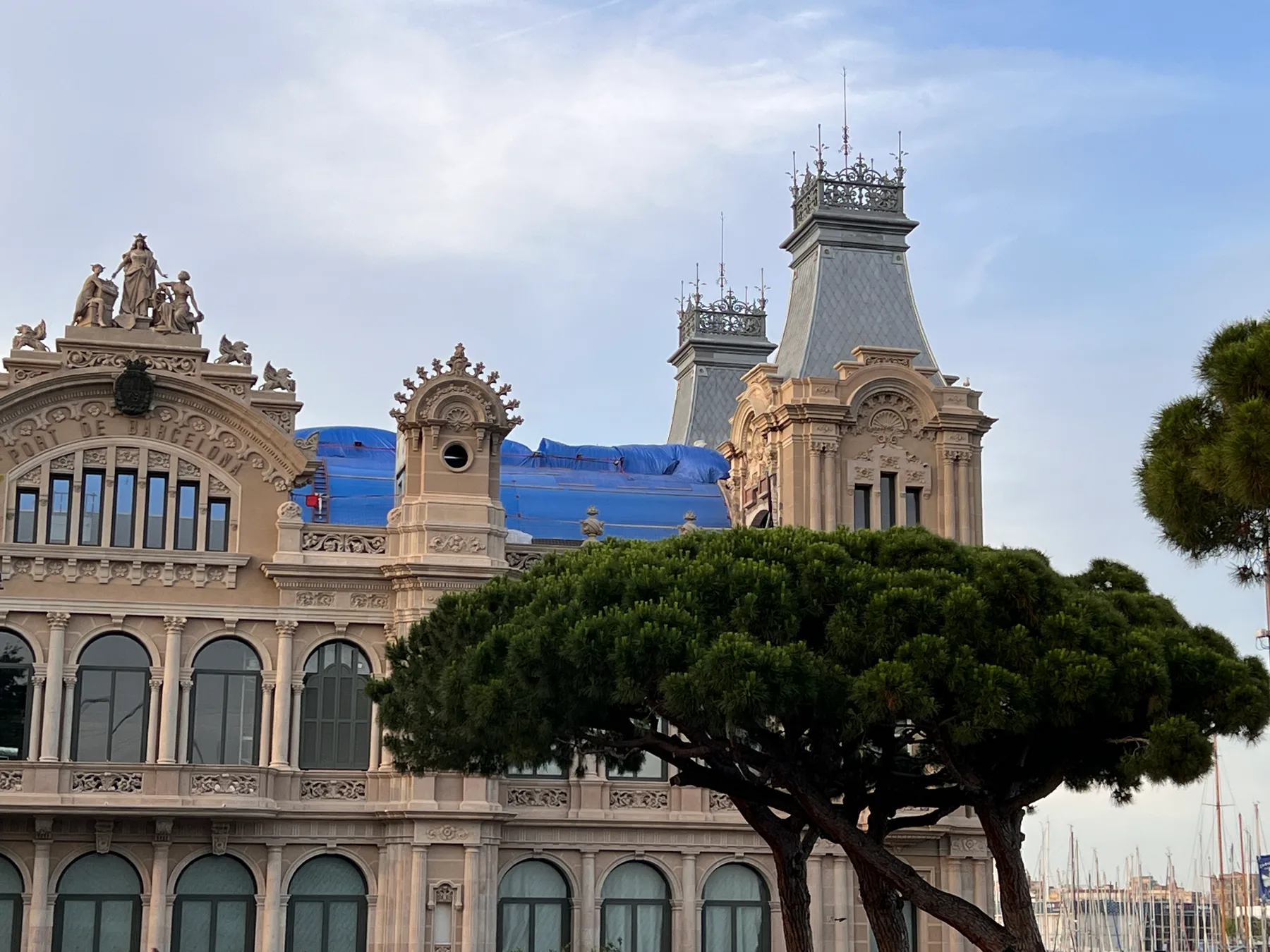Das historische Hafengebäude Port de Barcelona mit Palmen davor