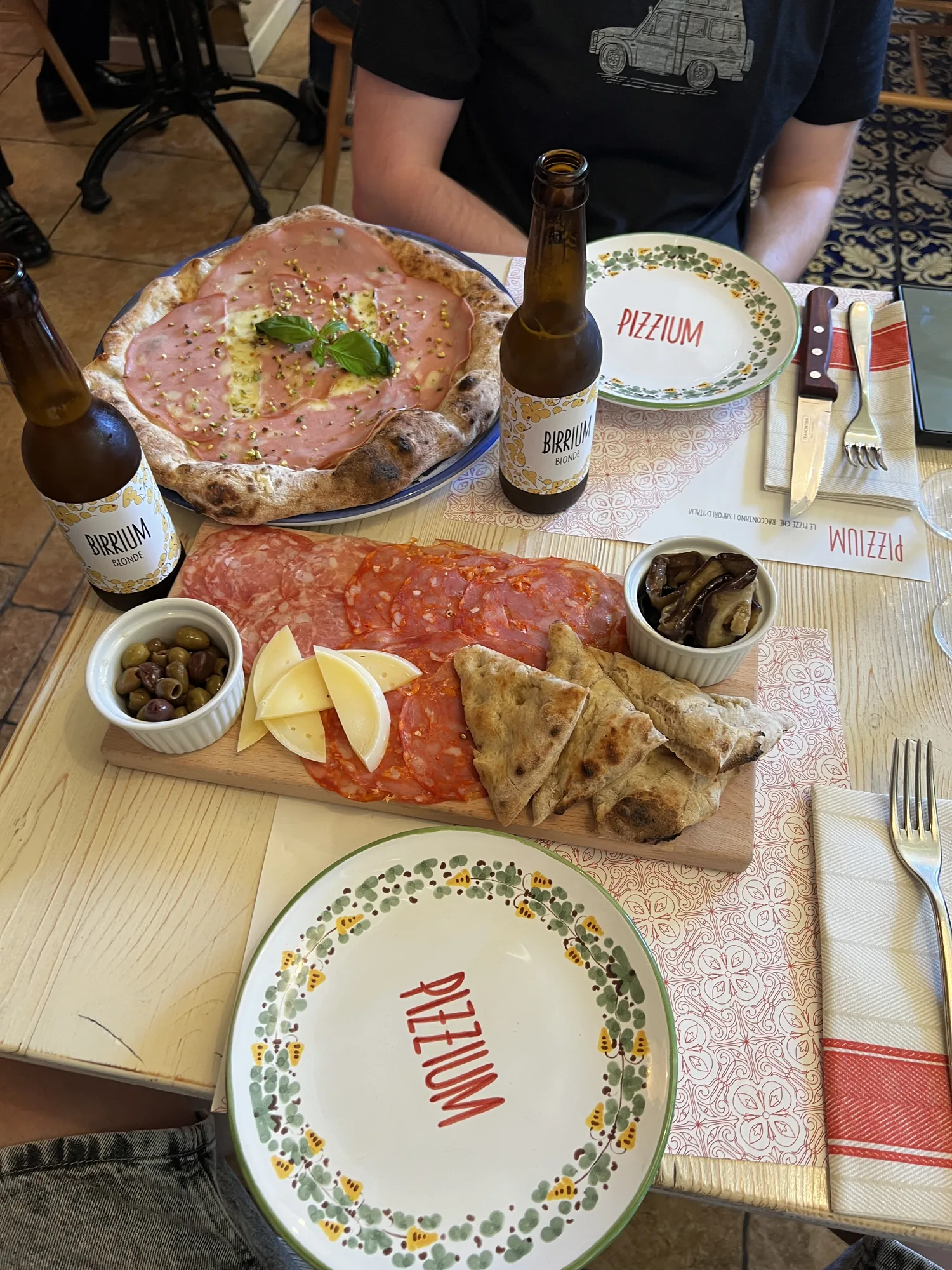 Pizza und ein Aufschnittbrett auf dem Tisch eines Restaurants in Mailand
